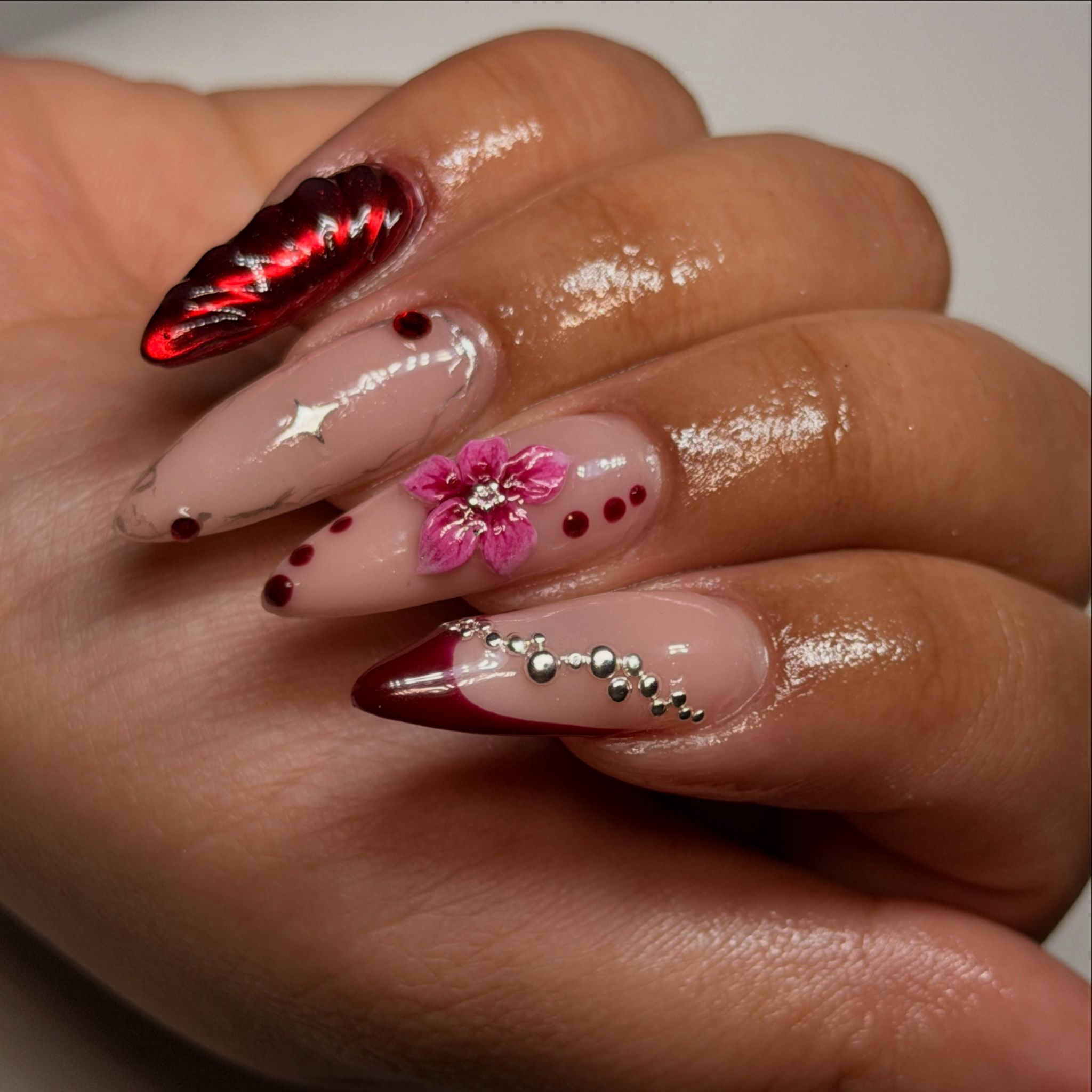 Gel-Nägel Schwechat – Bordeaux Chrome Stiletto mit 3D Blume und Silber-Details