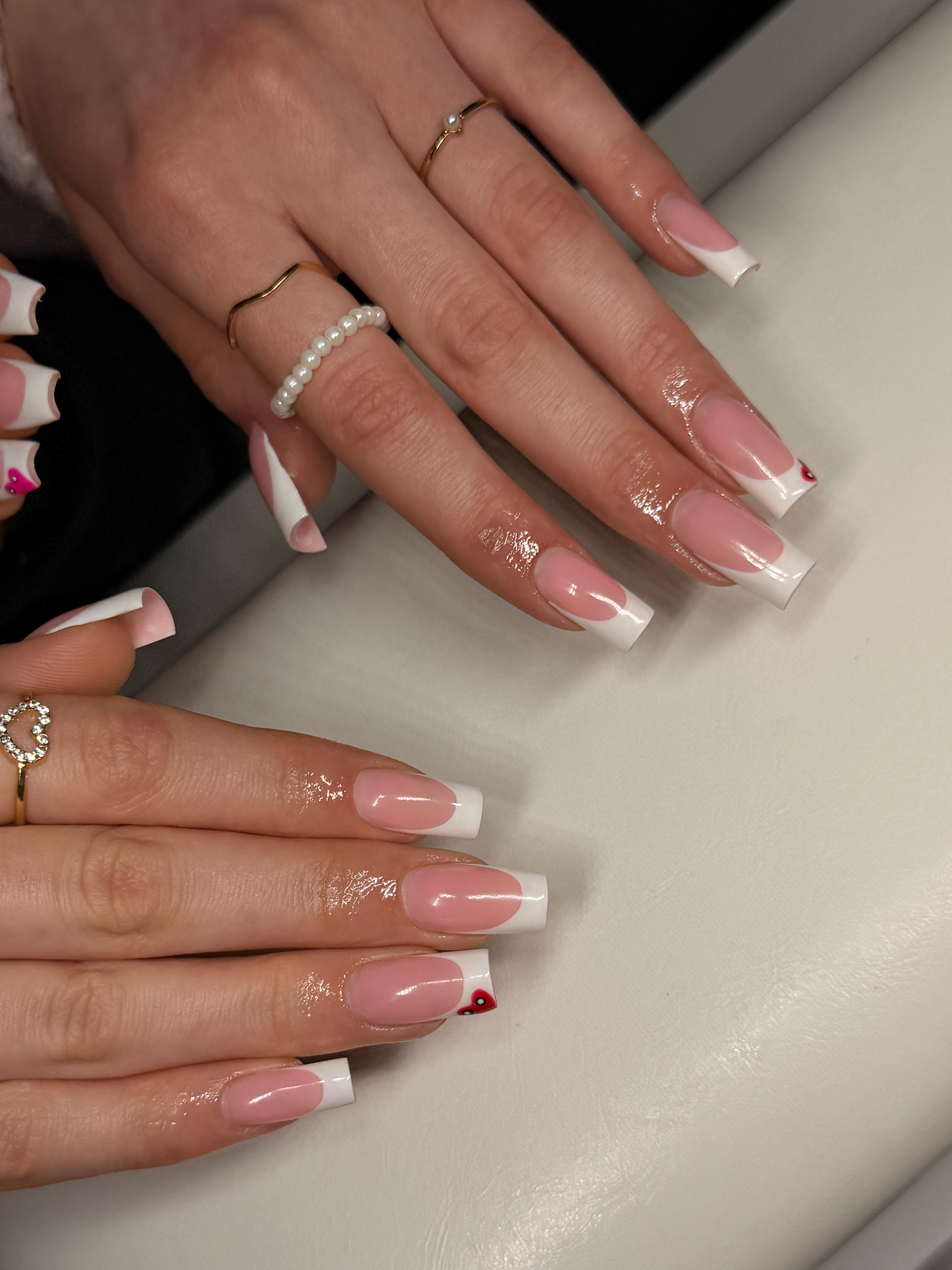 Gel-Nägel Schwechat – Zwei Hände mit French Manicure Square und Herzchen